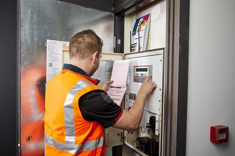 A Fire and Wire service technician providing fire safety maintenance