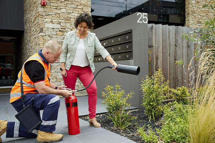 Fire and Wire technician demonstrates how to use a fire extinguisher