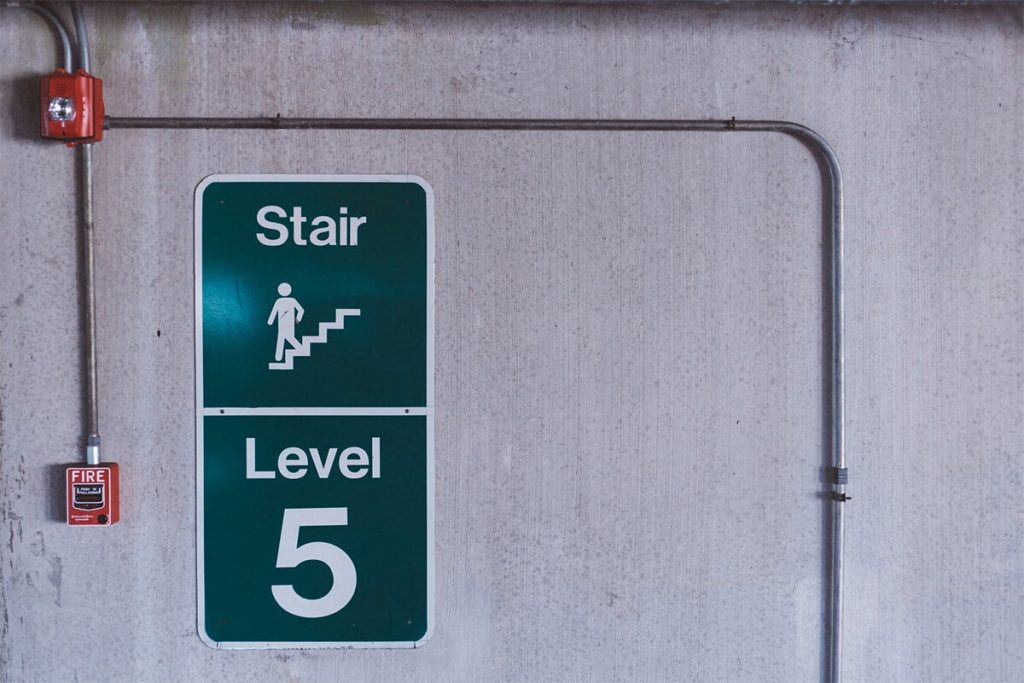 A green level 5 sign in a building fire stairway