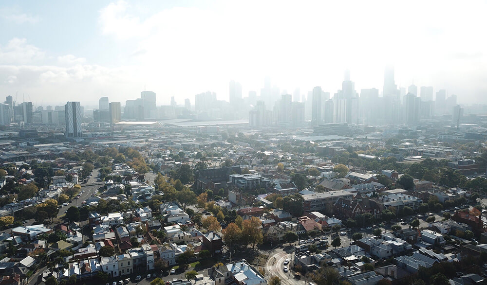 A birds-eye image of Melbourne’s city high-rises, with fog rolling in