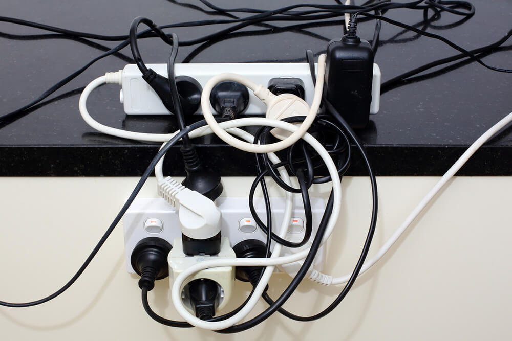 An unsafe, overloaded powerboard with too many electrical items plugged in